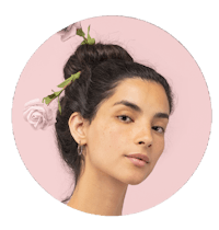 a woman with flowers in her hair on a pink background