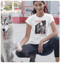 a woman kneeling down next to a dog wearing a white t - shirt
